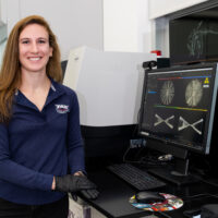 Jamie Knaub smiling and standing next to her CT data.