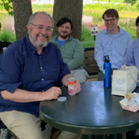 NYITCOM Anatomy faculty sitting by a pond eating lunch and smiling